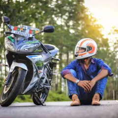 Giovane con casco da moto, pronto per allargare un casco stretto e partire per un'avventura.