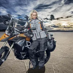 Donna in abbigliamento tecnico da moto, pronta per un'avventura. Ecco come vestirsi per andare in moto donna, con giacca e pantaloni protettivi.