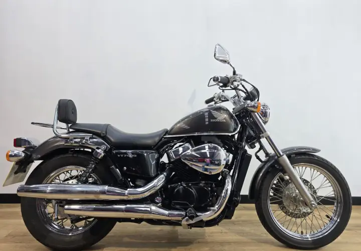 Honda VT750S cromata e scura, con sella nera e schienalino per il passeggero.