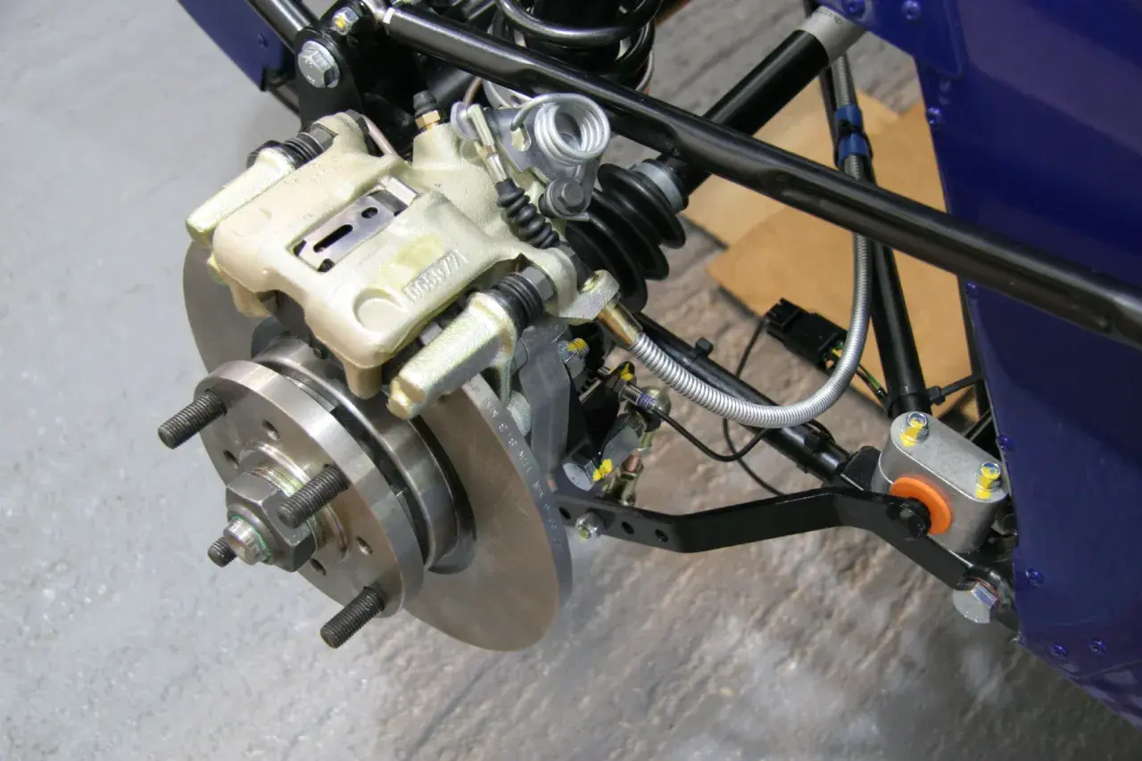 Dettaglio del sistema frenante di un veicolo, con pinza, disco e componenti di sospensione. Pronto per lo spurgo freni scooter.