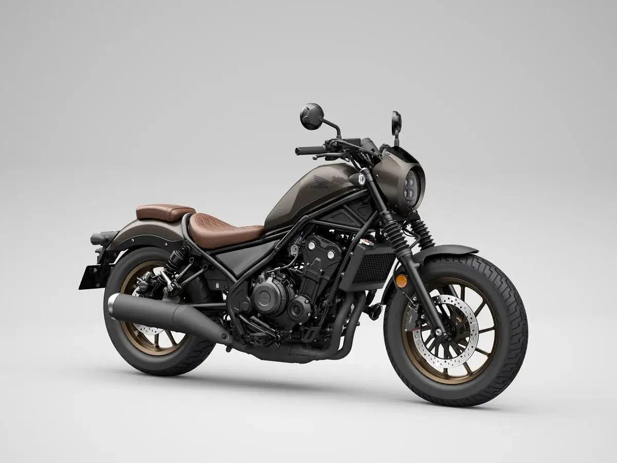 Moto custom bobber marrone con sella in pelle, cerchi color bronzo e faro tondo. Stile minimalista e aggressivo.